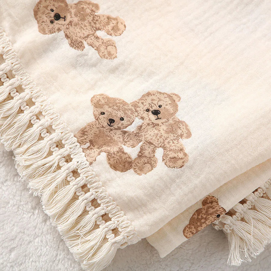 "Featuring a charming bear design and breathable cotton muslin fabric, this blanket is made for sweet dreams and gentle cuddles."